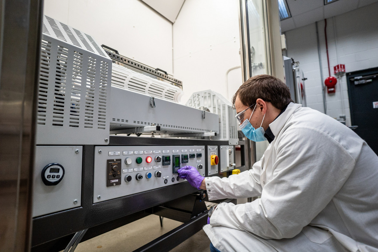 An image of a researcher testing batteries in a lab setup